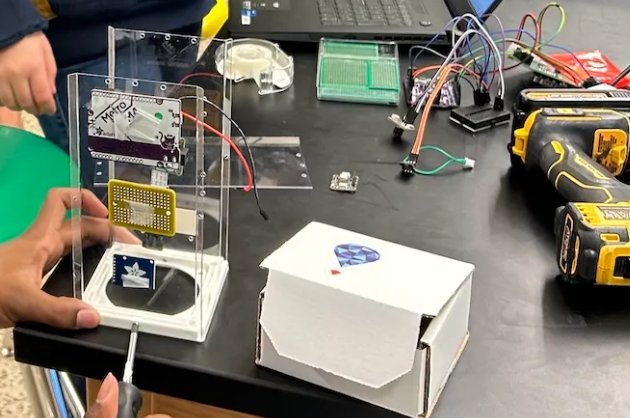 Student assembling a payload with a screwdriver
